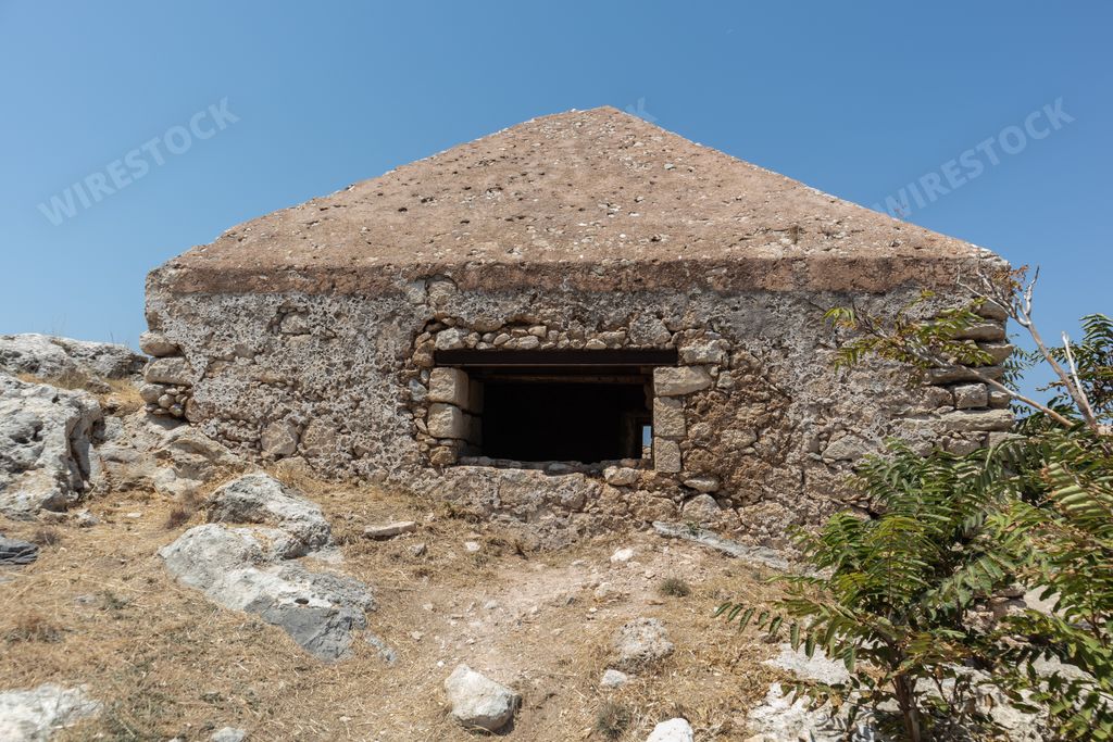 An old ruined building of the Venetian Fortezza Castle under a blue sky and sunlight in Rethymno, Greece