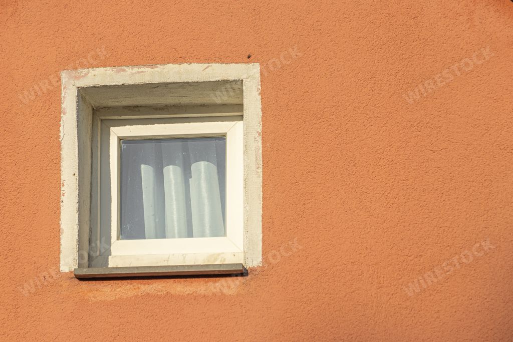 A beautiful view of a window on the facade of an orange building