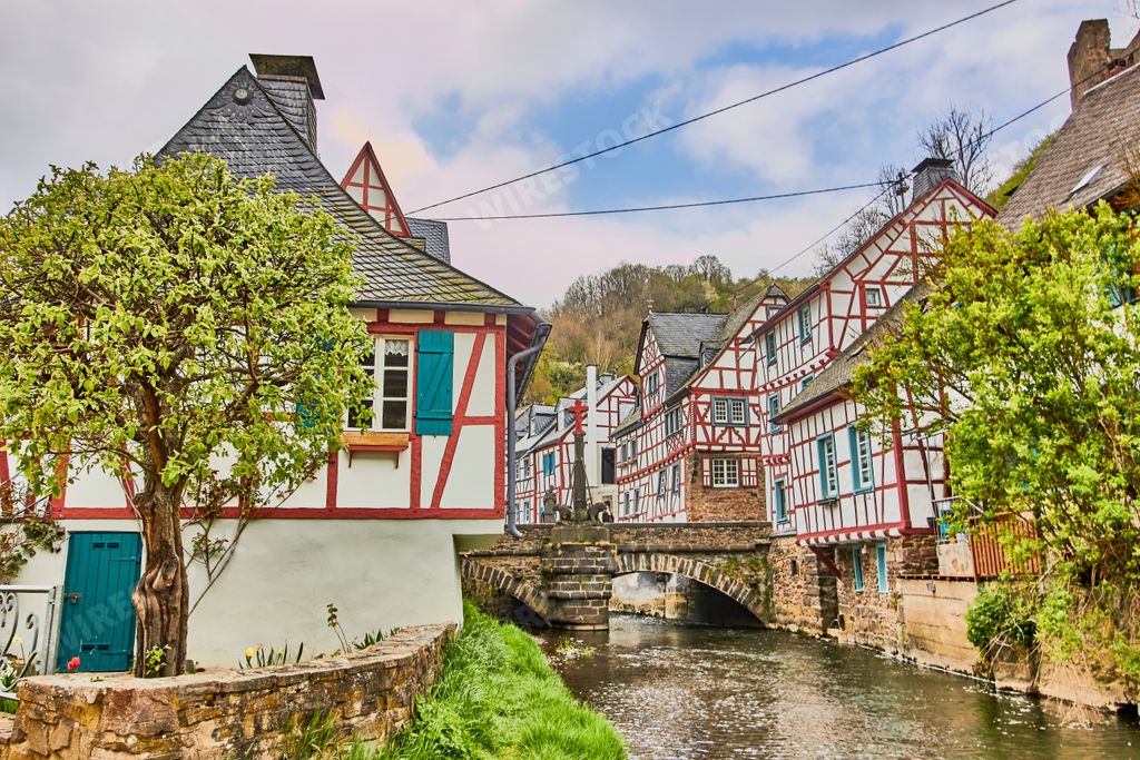 A beautiful shot of a river bridge between houses in Monreal, Germany with a blue cloudy sky