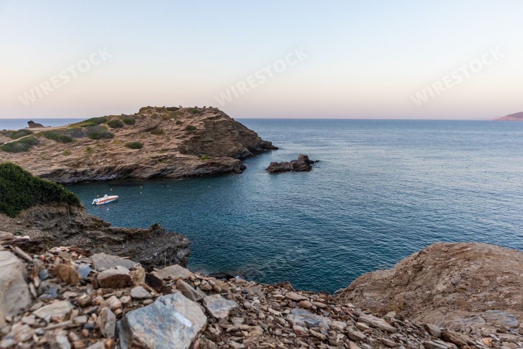 A beautiful view of blue water and rocky cliff under blue sunny sky in Bali Last Beach, Bali, Greece