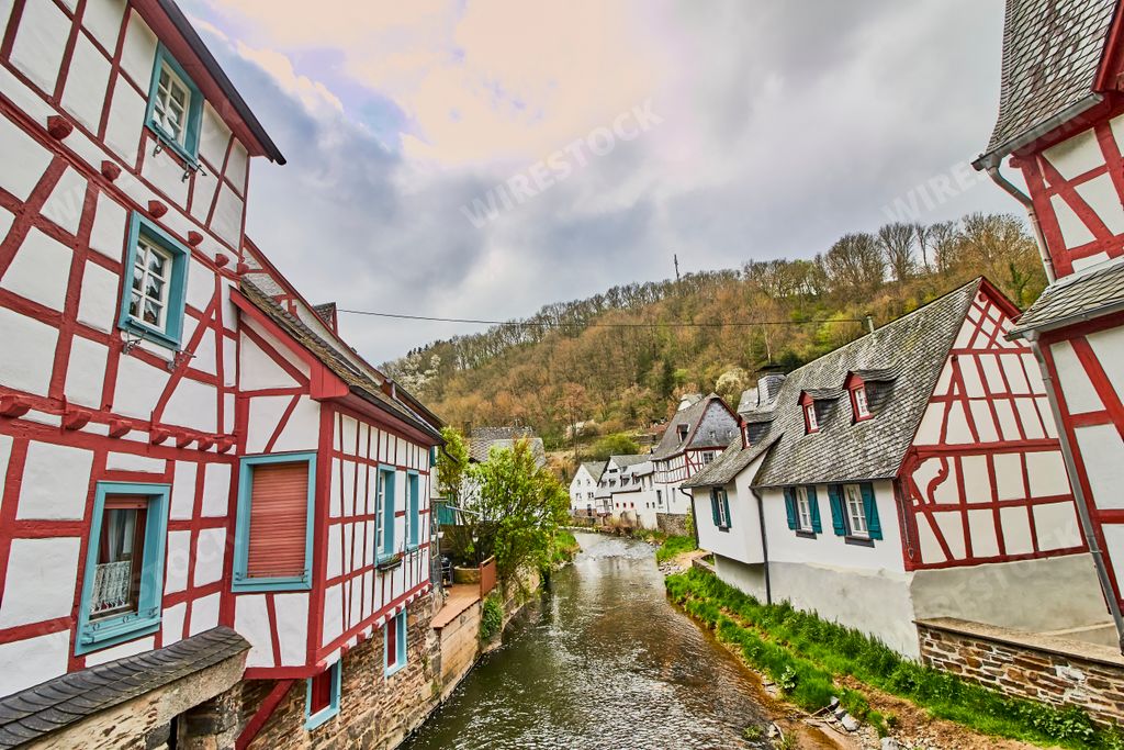 A beautiful shot of a river bridge between houses in Monreal, Germany with a blue cloudy sky