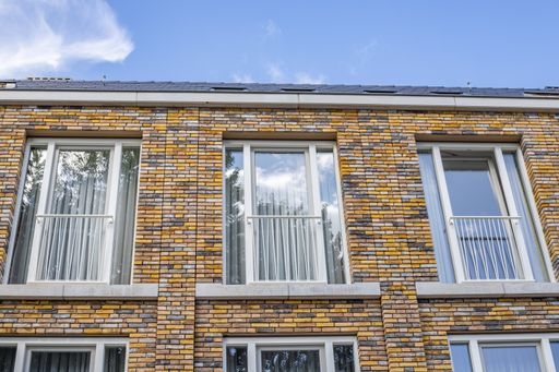 Vertical closeup shot of a modern brown and grey brick building with ...