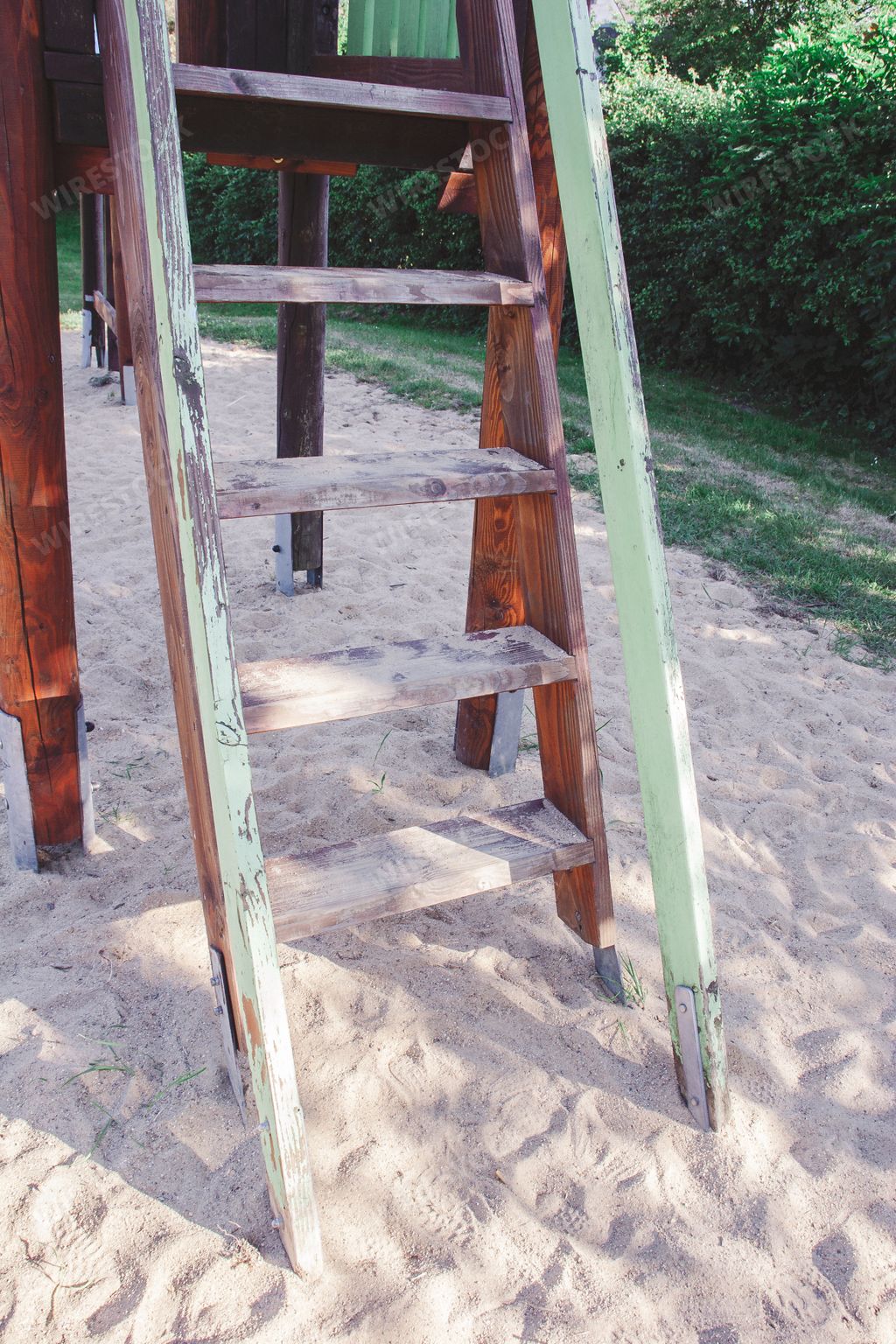 A vertical shot of wooden staircase on the sand in a park
