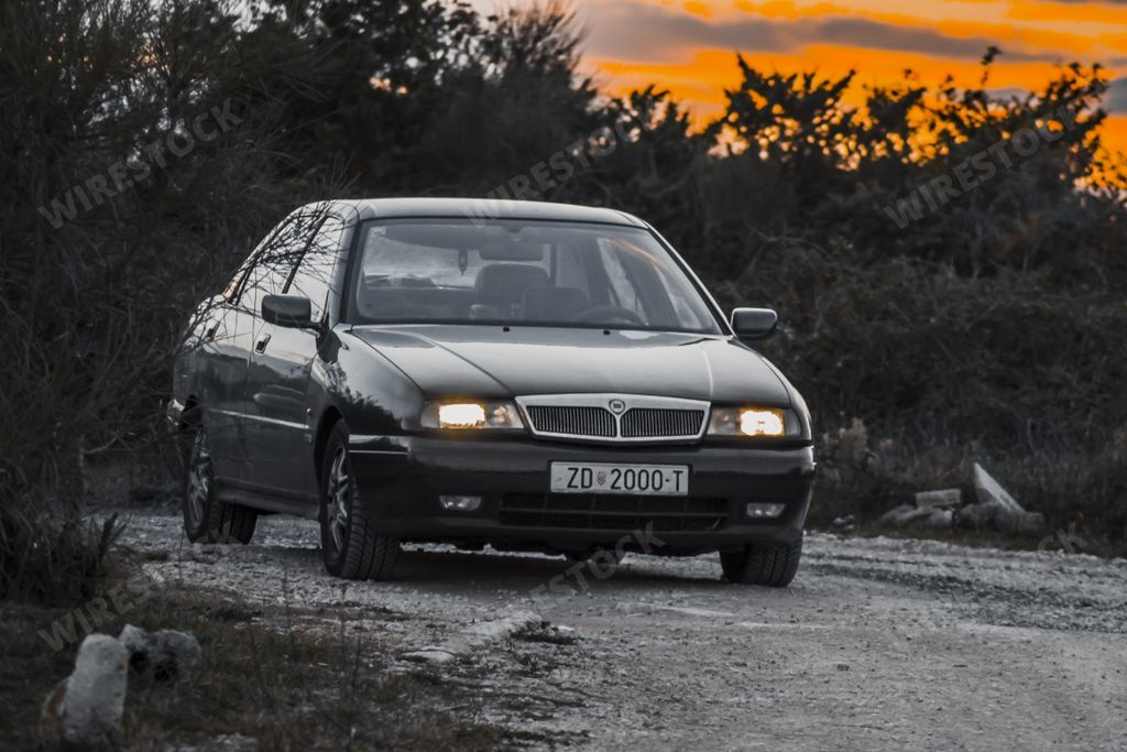 Lancia kappa turbo, classic executive Italian car on a gravel road in a golde sunset