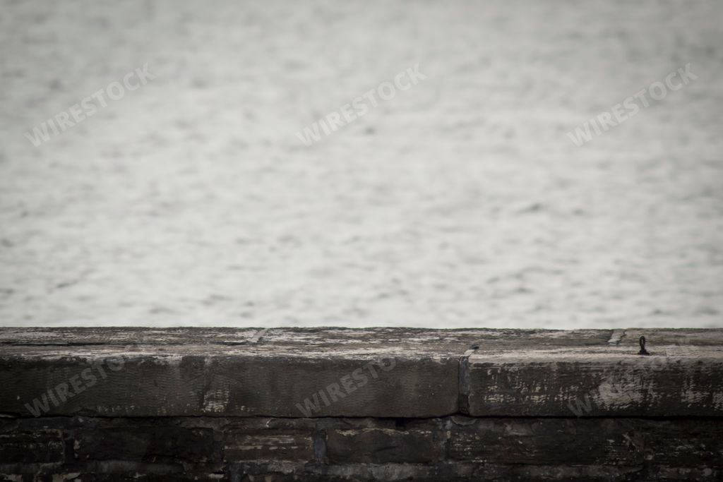 A stone dock and the sea in background at sunset