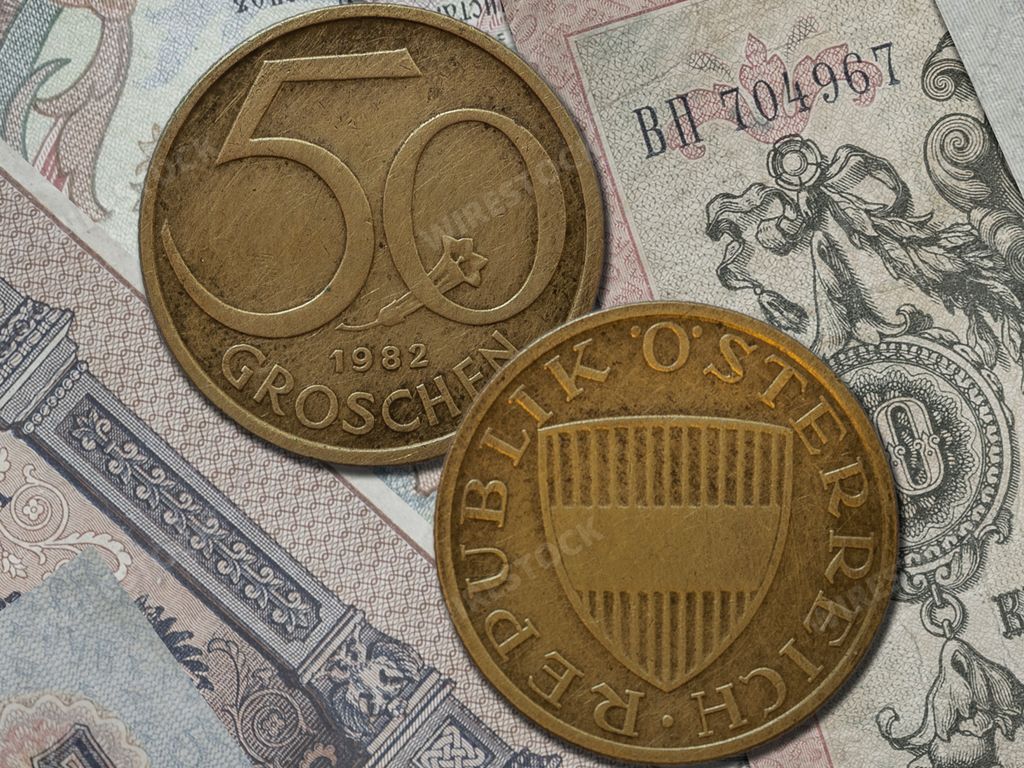 A closeup of Austrian schilling coin (50 groschen) isolated on banknotes background
