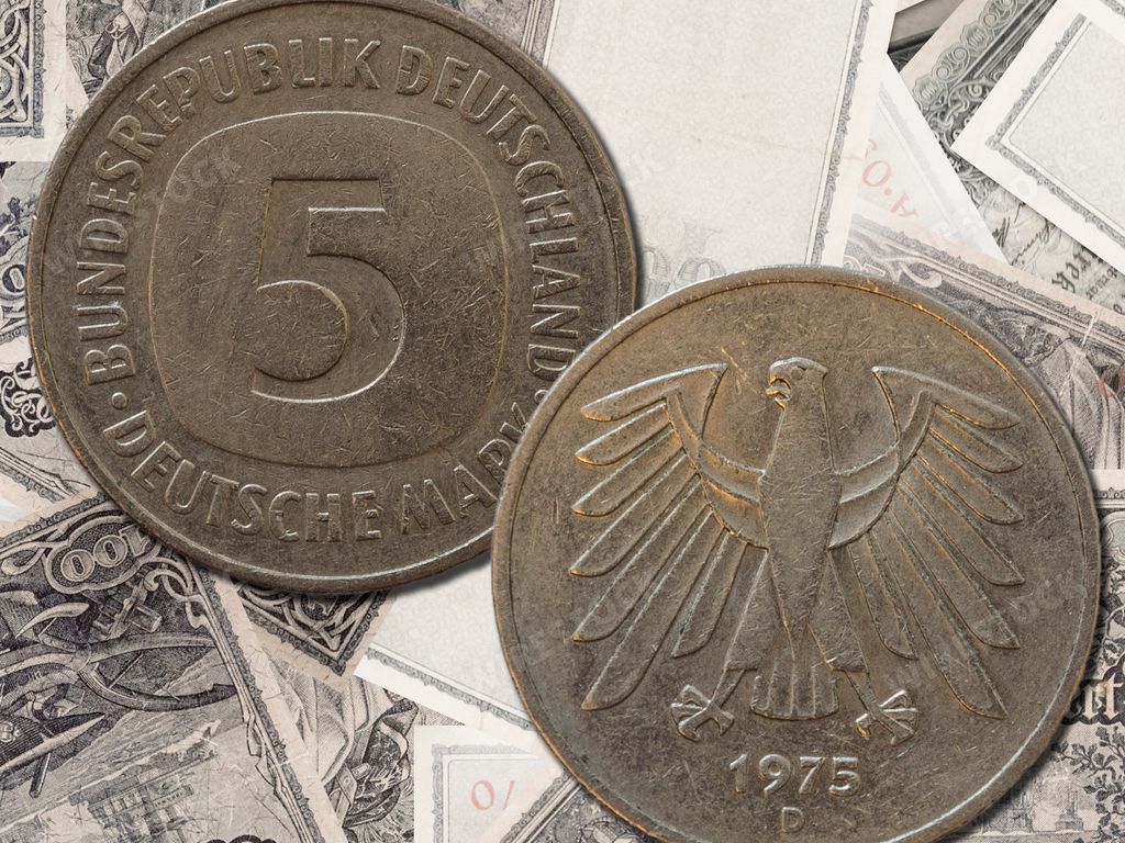 A top view of the front and back of a historic West Germany deutsche mark coin on a paper background