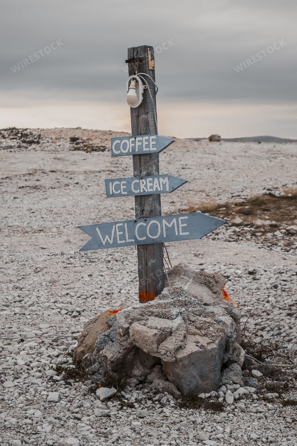 A vertical shot of a pile with arrowed signs on the beach