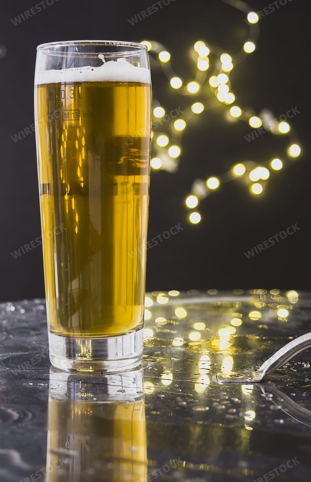 A vertical shot of a glass of beer with bokeh background