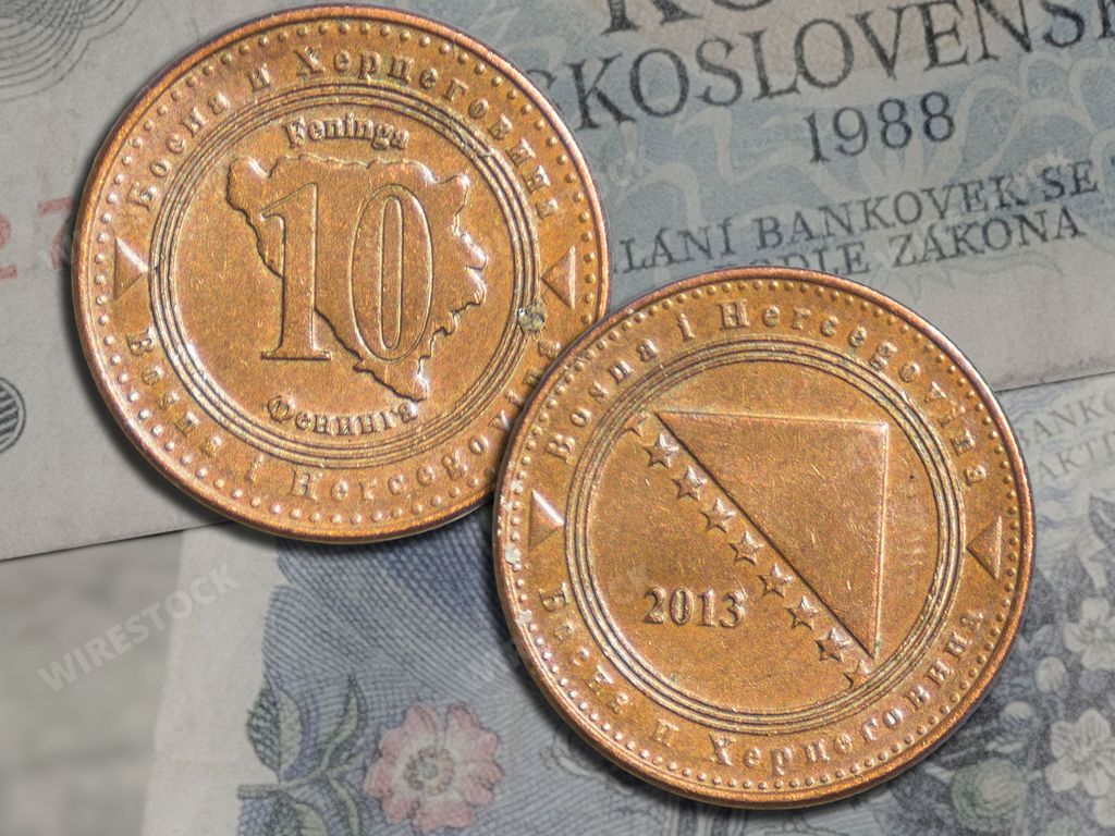 The Bosnia and Herzegovina 10 fenings coins on a banknotes background. Close-up on two sides.