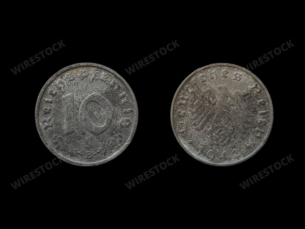 An isolated shot of both sides of a vintage 1942 Reich pfennig coin from nazi Germany, black background