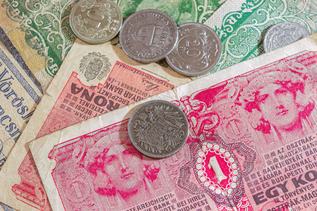 A closeup of Austrian and Hungarian coins from the early 1900s, including Heller, Filler, and Krone denominations