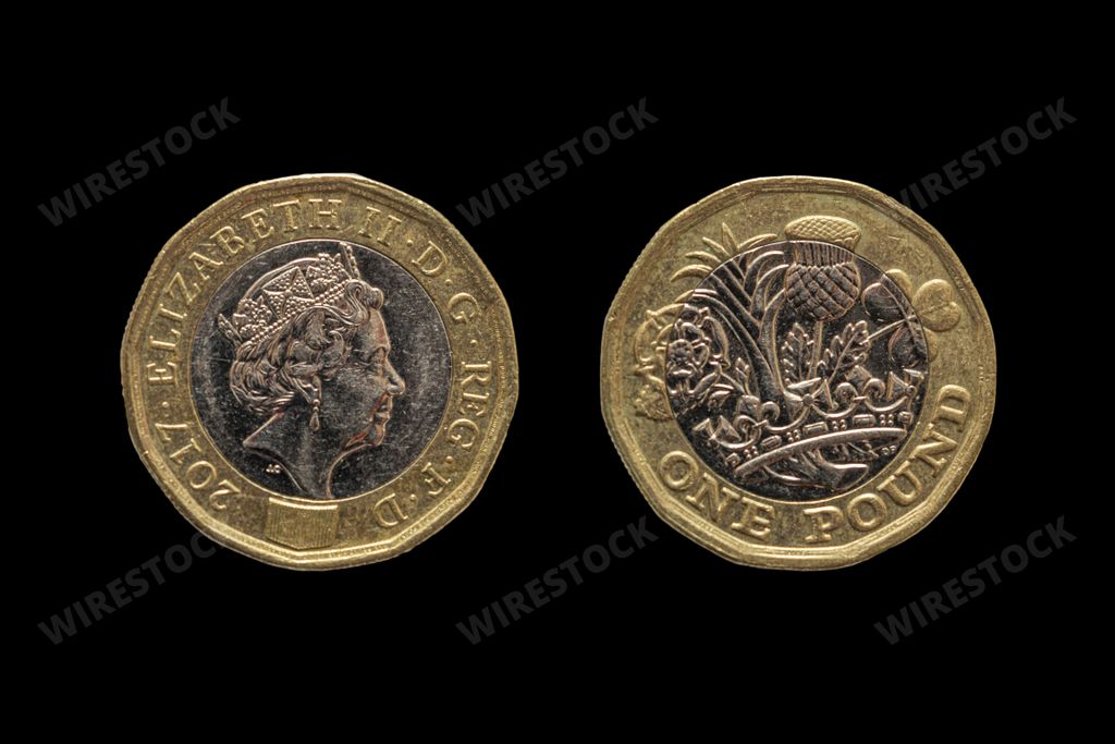 A top view closeup of British coins obverse and reverse on a black background