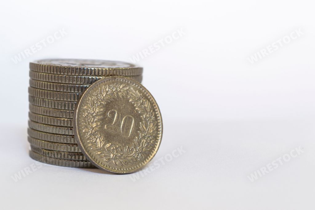 A close-up image of a stack of Swiss franc coins with a white background