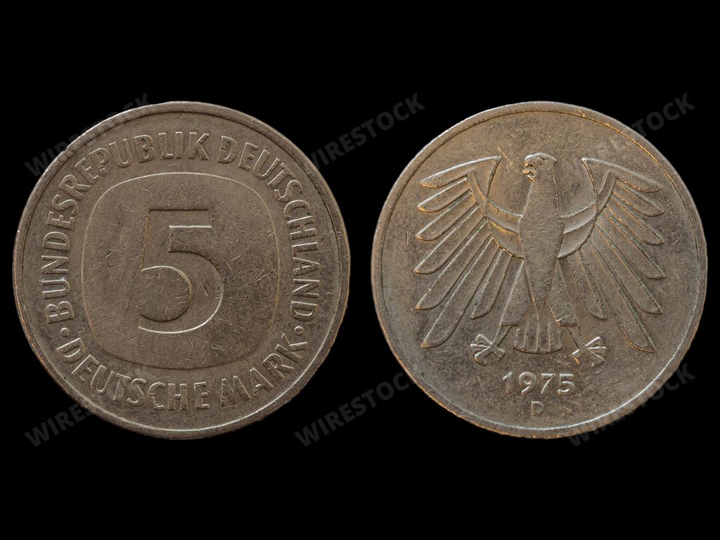 A top view of the front and back of a historic West Germany deutsche mark coin on a black background