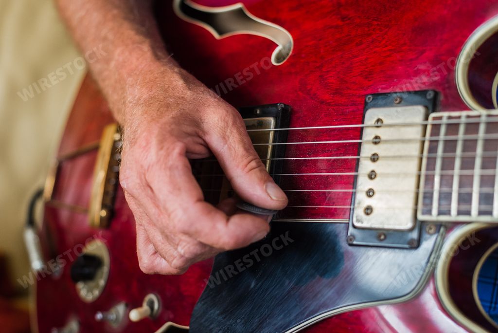 A closeup shot of a person playing an electric guitar