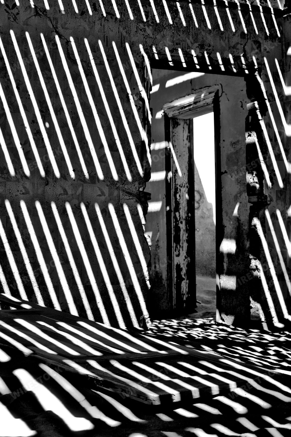 A vertical shot of an abandoned house interior with shadows in ghost town Kolmanskop, Namibia