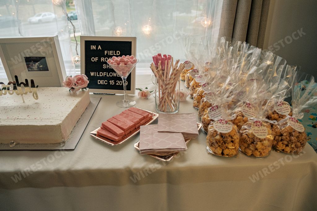 A dessert table with party favors, marshmallow, wafers cookies and sticks, cake and table napkin,
