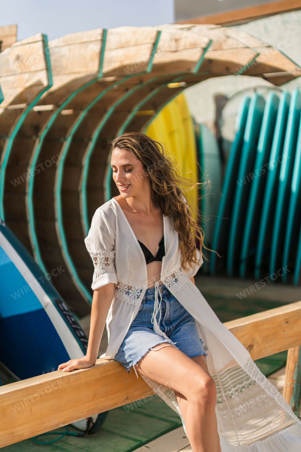 A vertical shot of a young, beautiful Spanish woman posing by the beach
