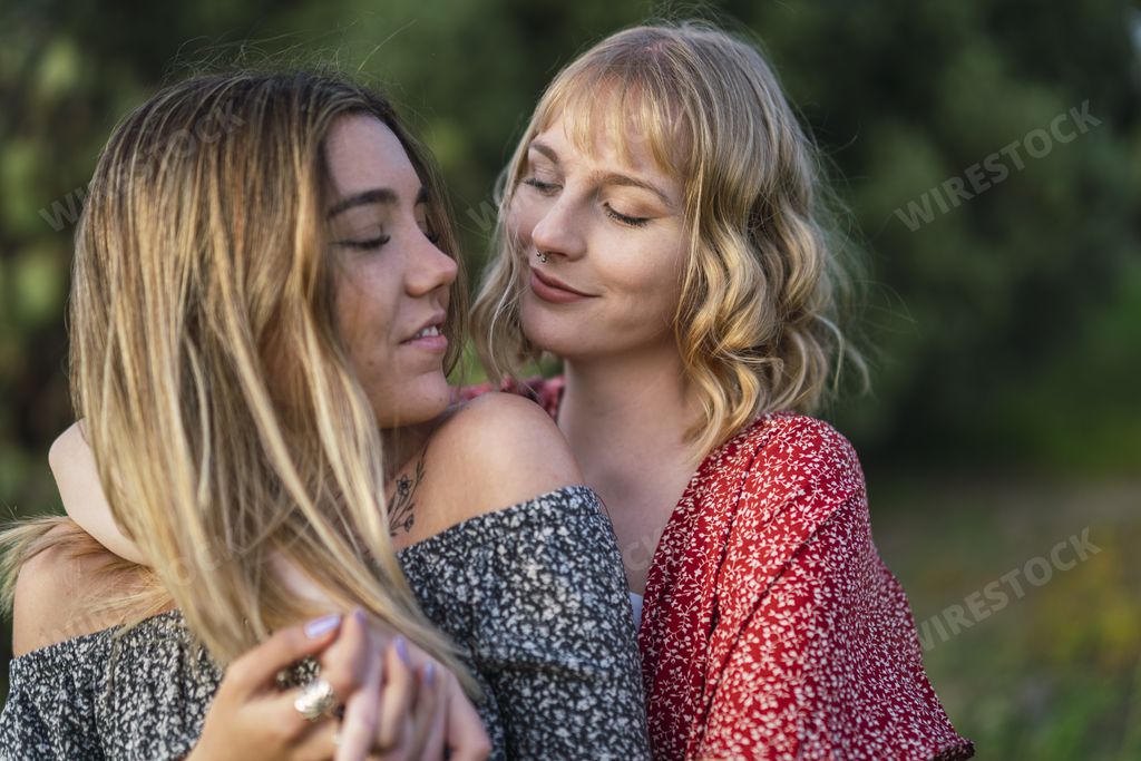 A happy lesbian couple cuddling each other in nature