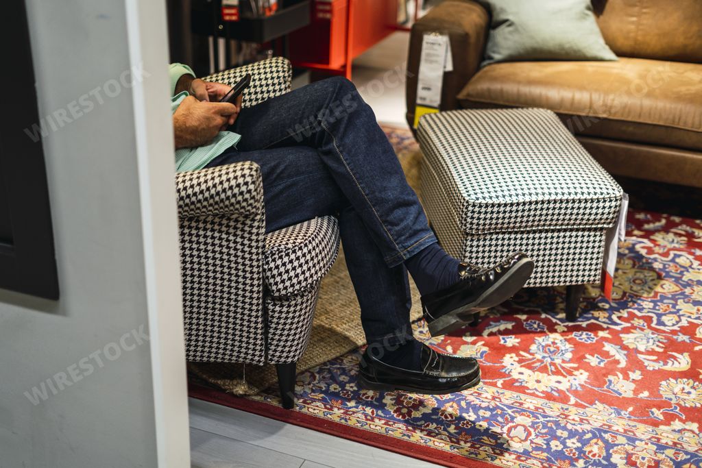 A closeup shot of male feet wearing jeans sitting on the chair