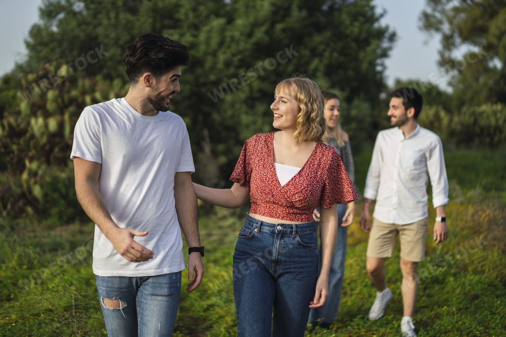 A shallow focus shot of Spanish Caucasian young friends hanging out in a park, two couples