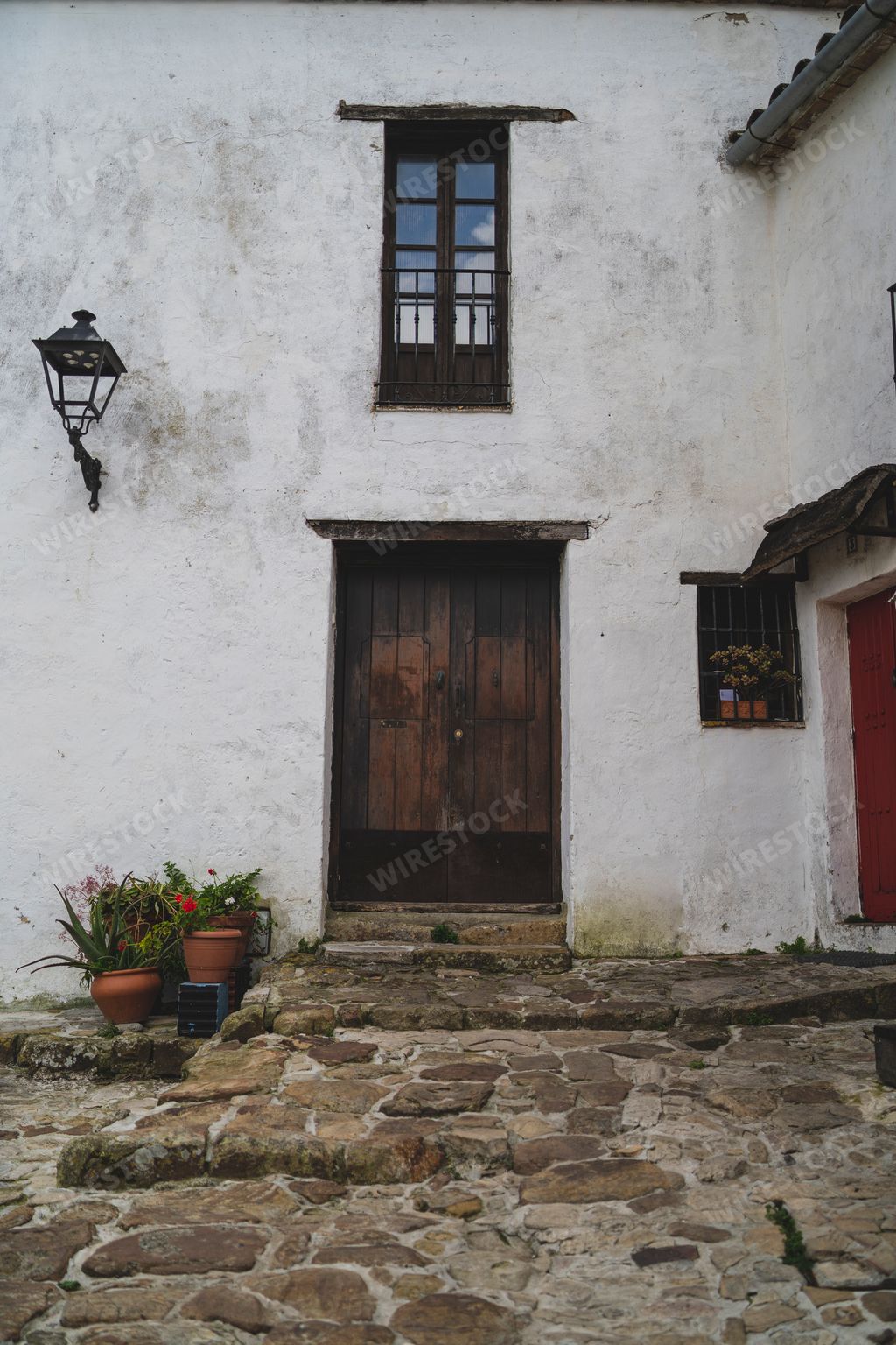 A beautiful view of a wooden door in the white building of a small town in Spain