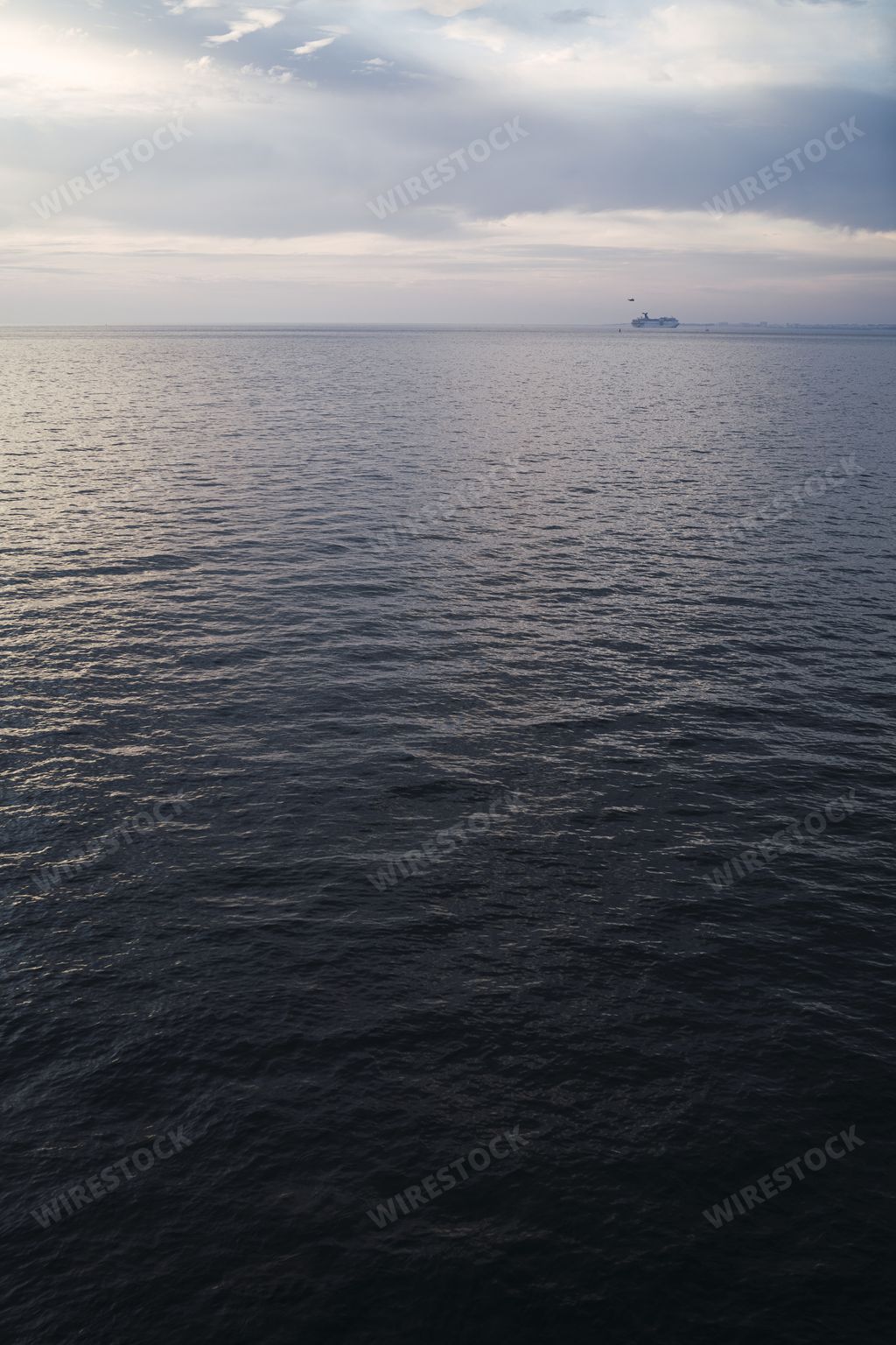 A vertical shot of a dark calm sea under a bright sky in Cadiz, Andalusia, Spain