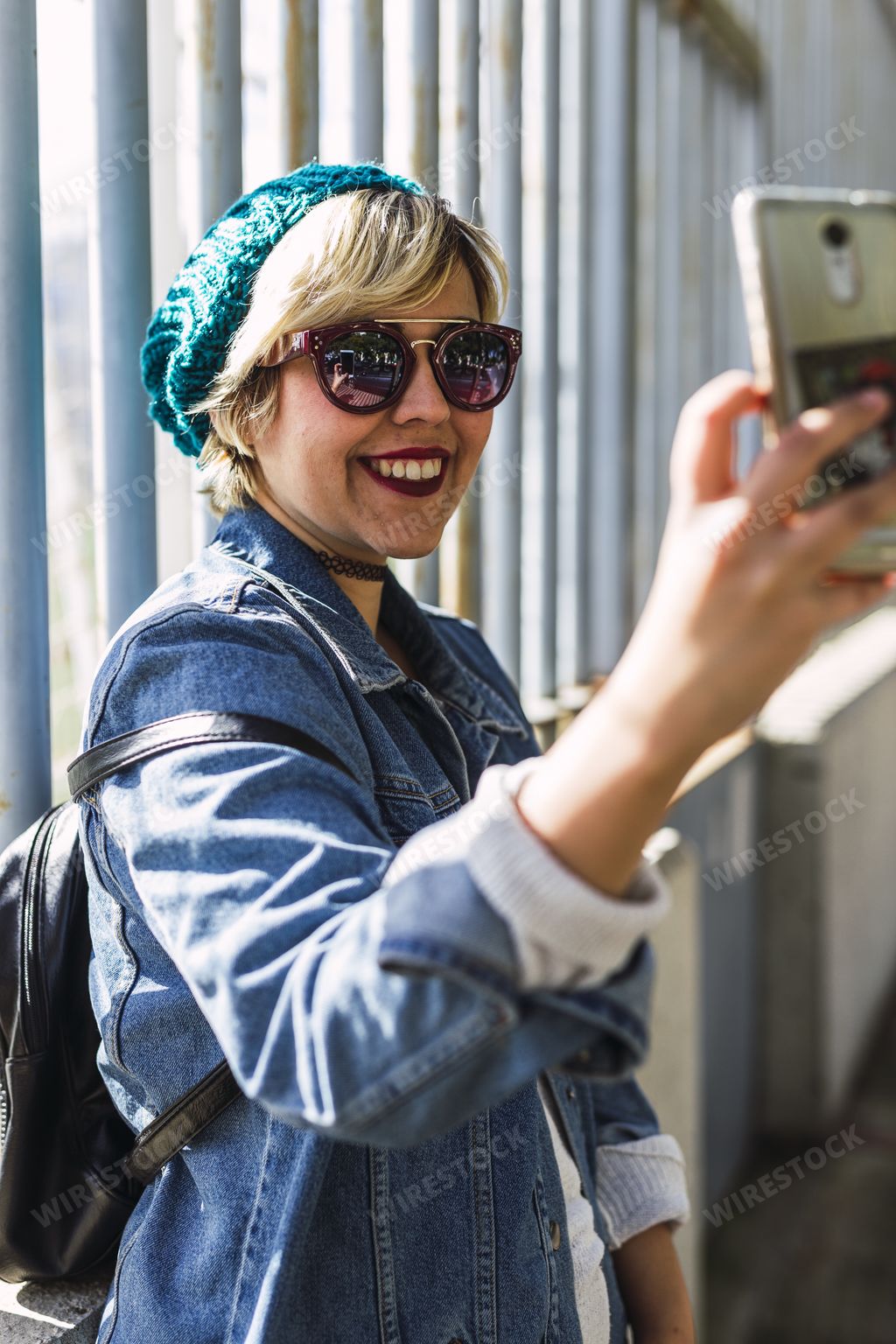 A young Caucasian female walking on the street and taking a selfie