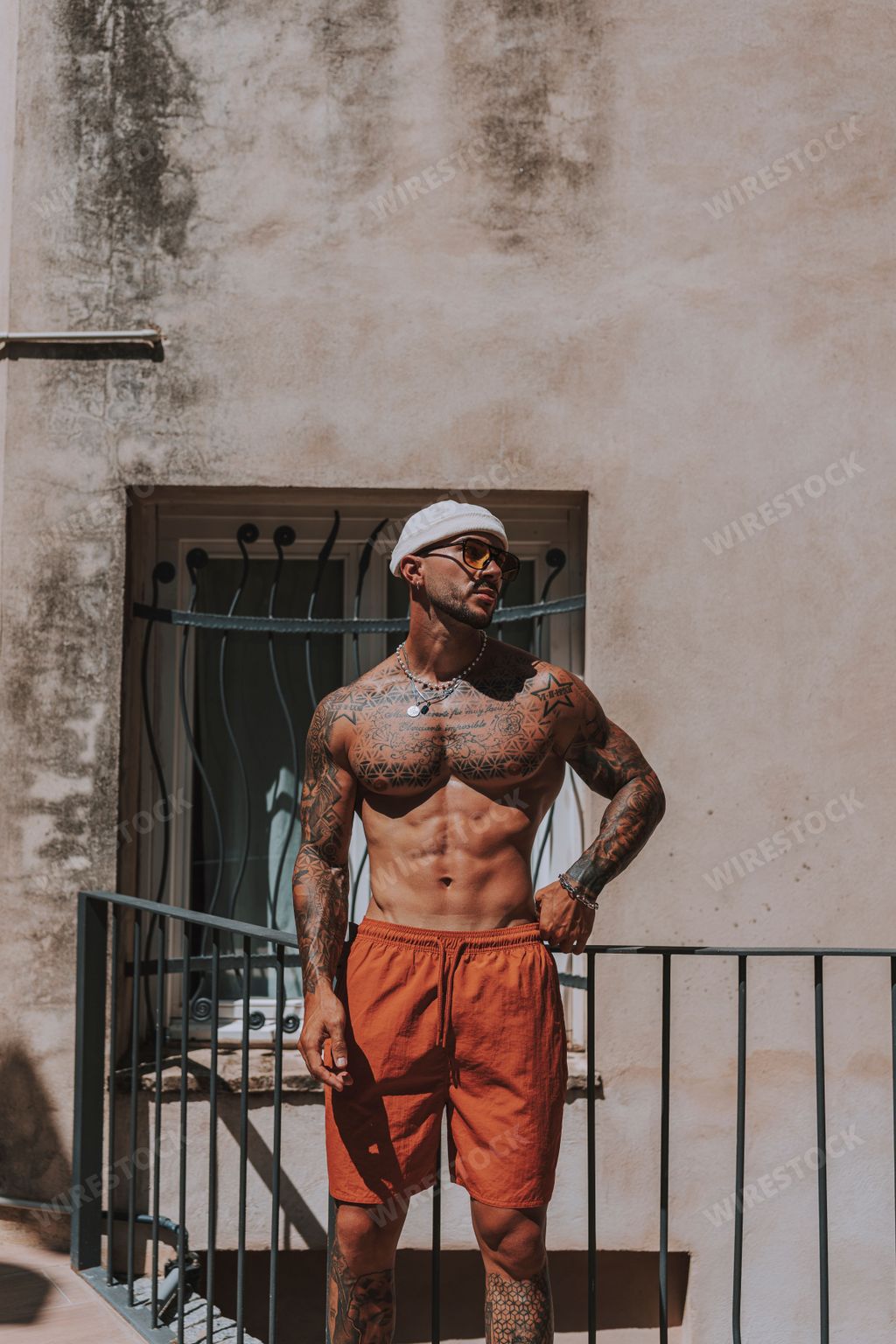 A young man with tattoos posing and enjoying the sunny weather on a hot summer day