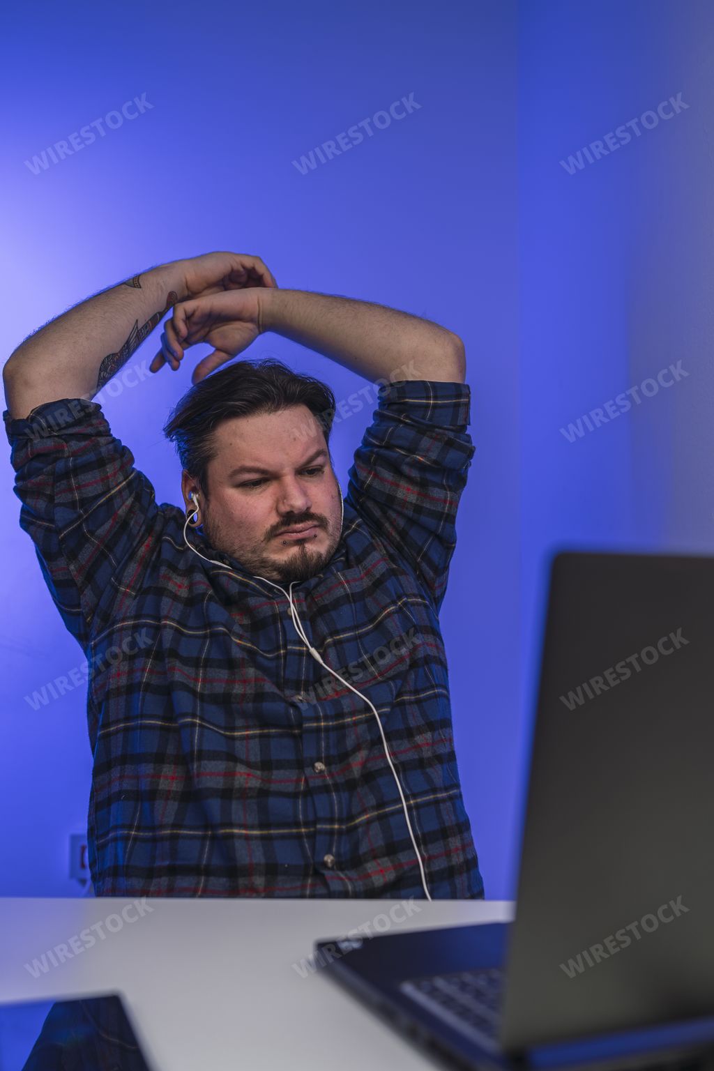 An exhausted man leaning on his chair while working