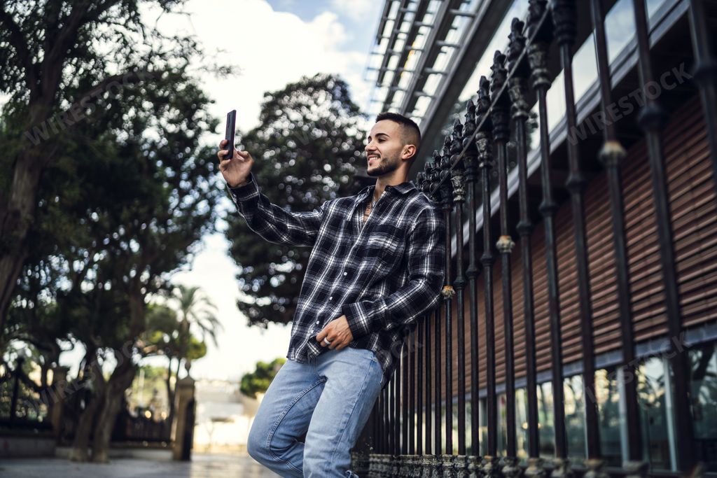 A young attractive male taking a selfie outdoors