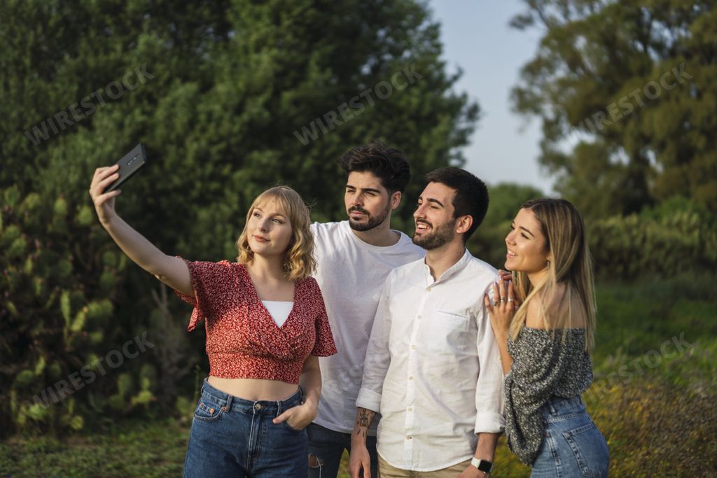 A shallow focus shot of Spanish Caucasian young friends taking a selfie in a park