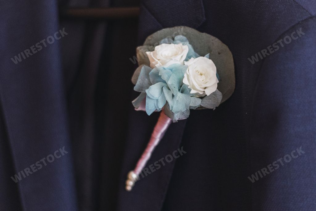 A close up shot of wedding boutonniere on the black suit