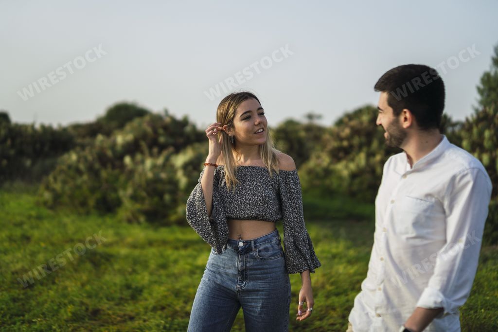 A shallow focus shot of a Spanish Caucasian young couple hanging out in a park
