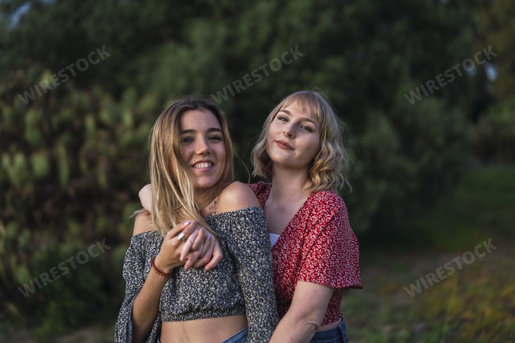 A happy lesbian couple cuddling each other in nature