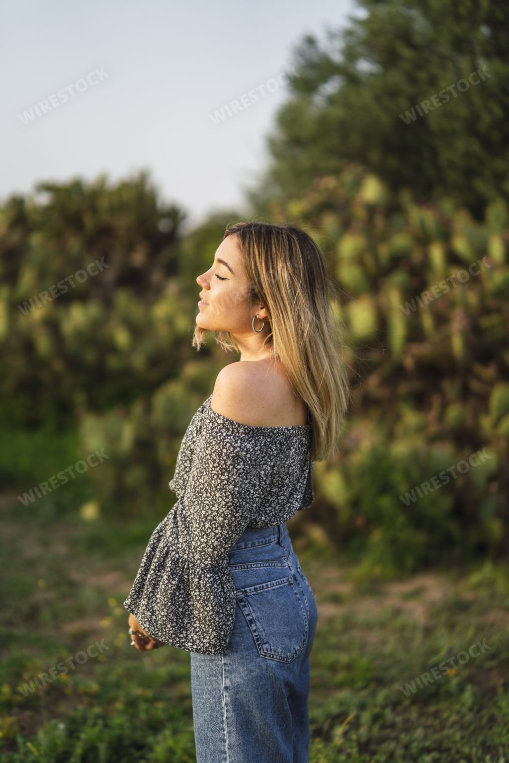 A vertical shot of a beautiful Spanish Caucasian young woman posing in the park