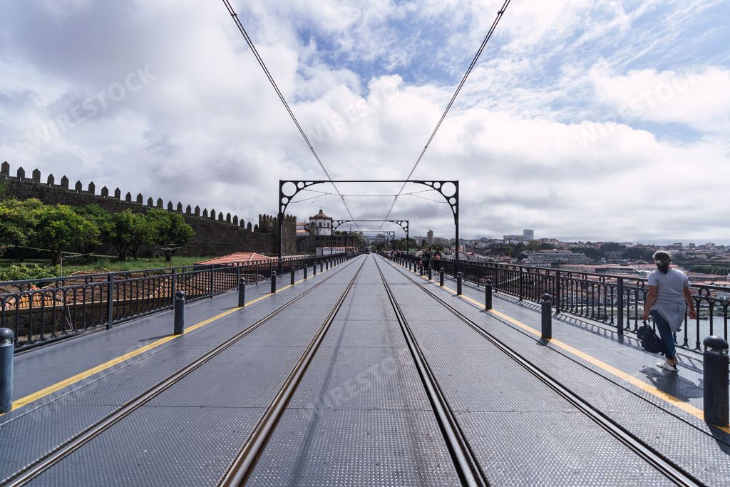 A scenic view of a bridge in Porto, Portugal on a cloudy sky background