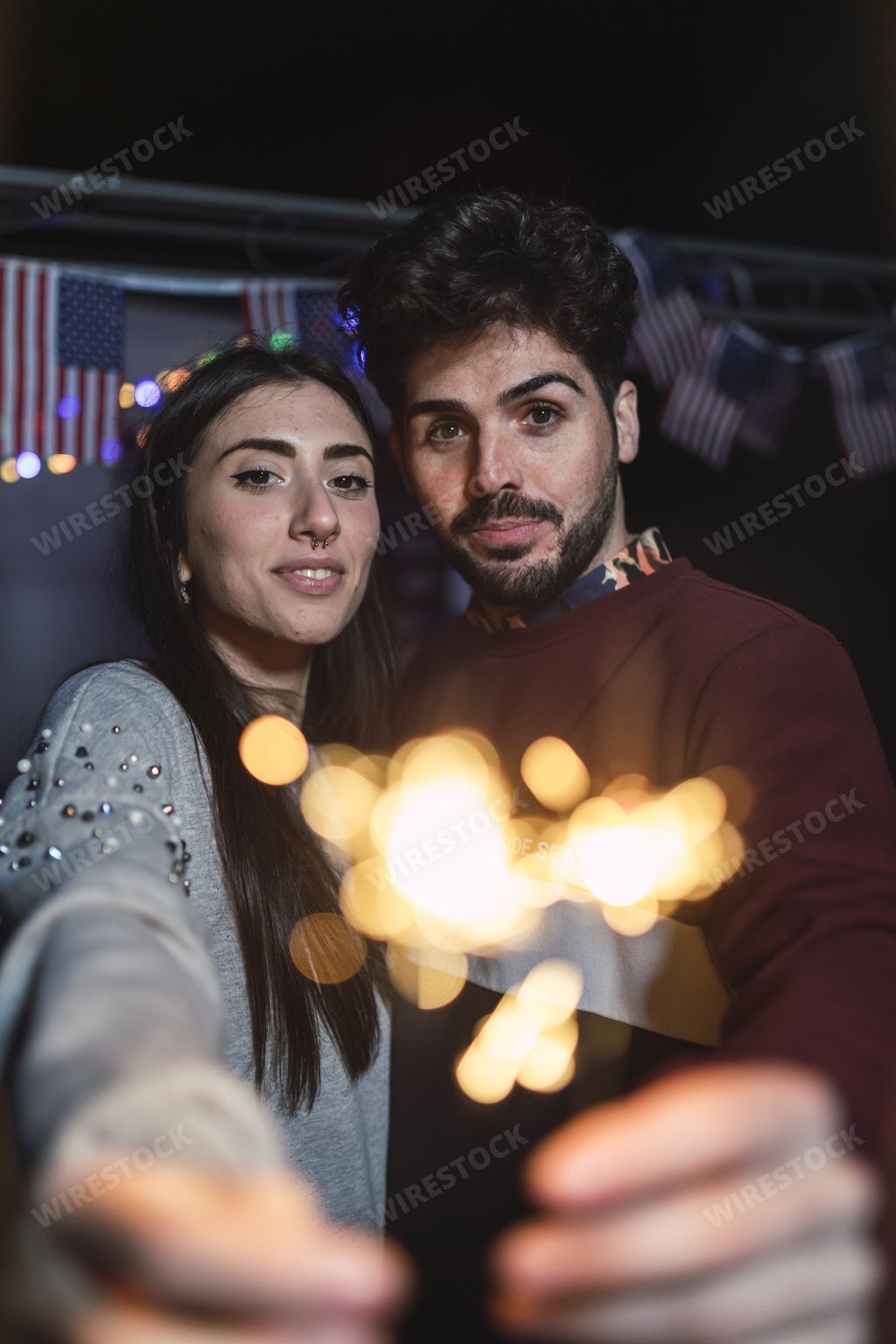 A loving Spanish couple doing a selfie with sparklers at night