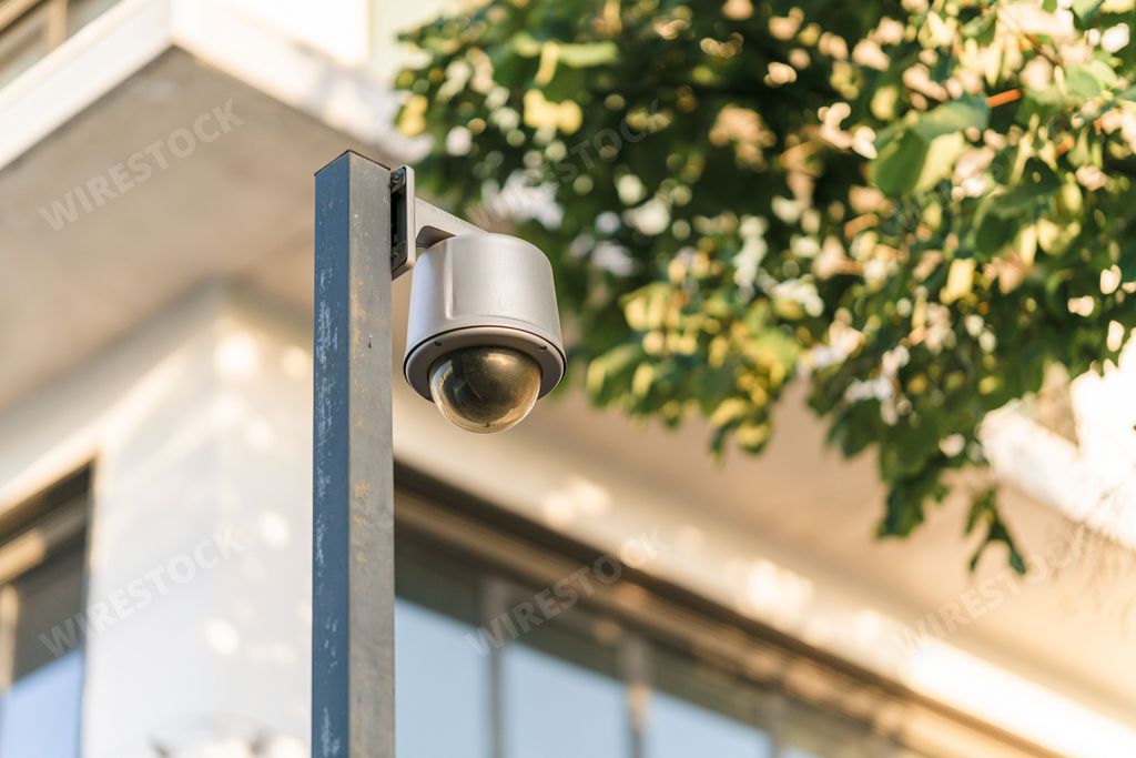 The low-angle view of a security camera column before a residential building