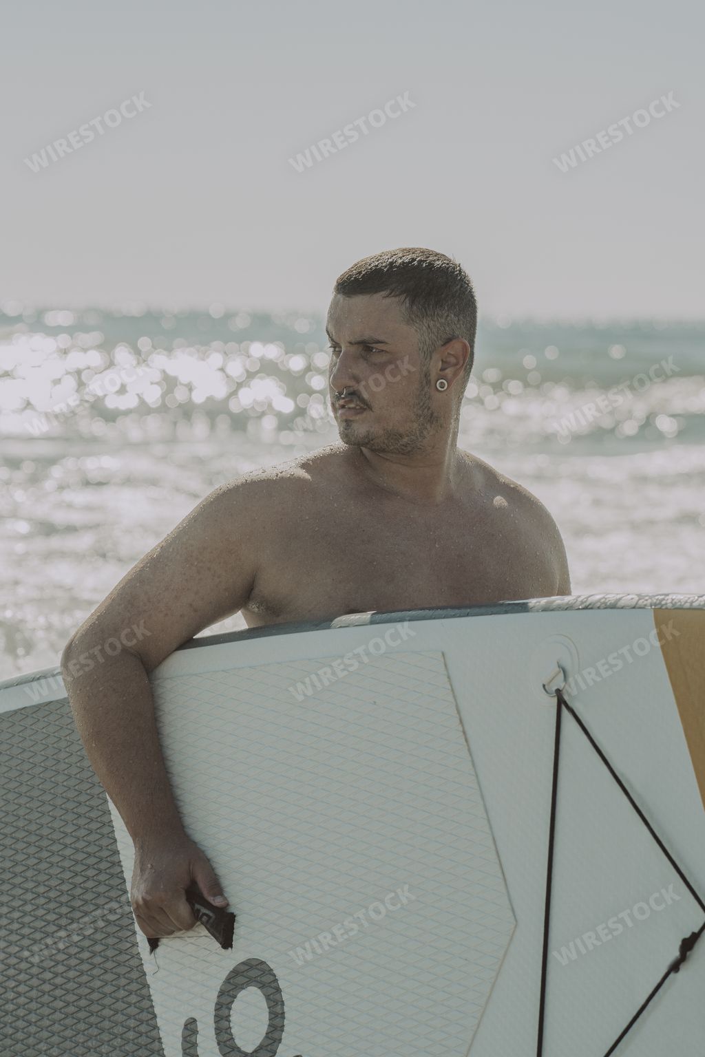 A vertical shot of a Caucasian male surfing in Cadiz, Andalucia