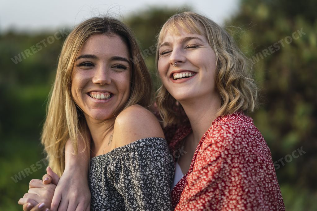A happy lesbian couple cuddling each other and laughing