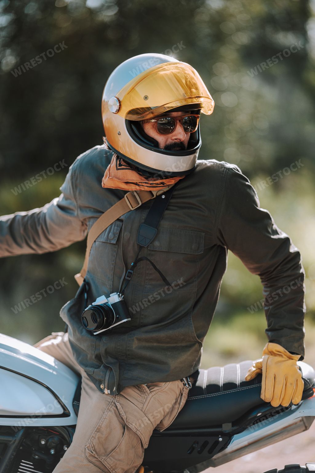 A motorcyclist in safety gear sits on his bike
