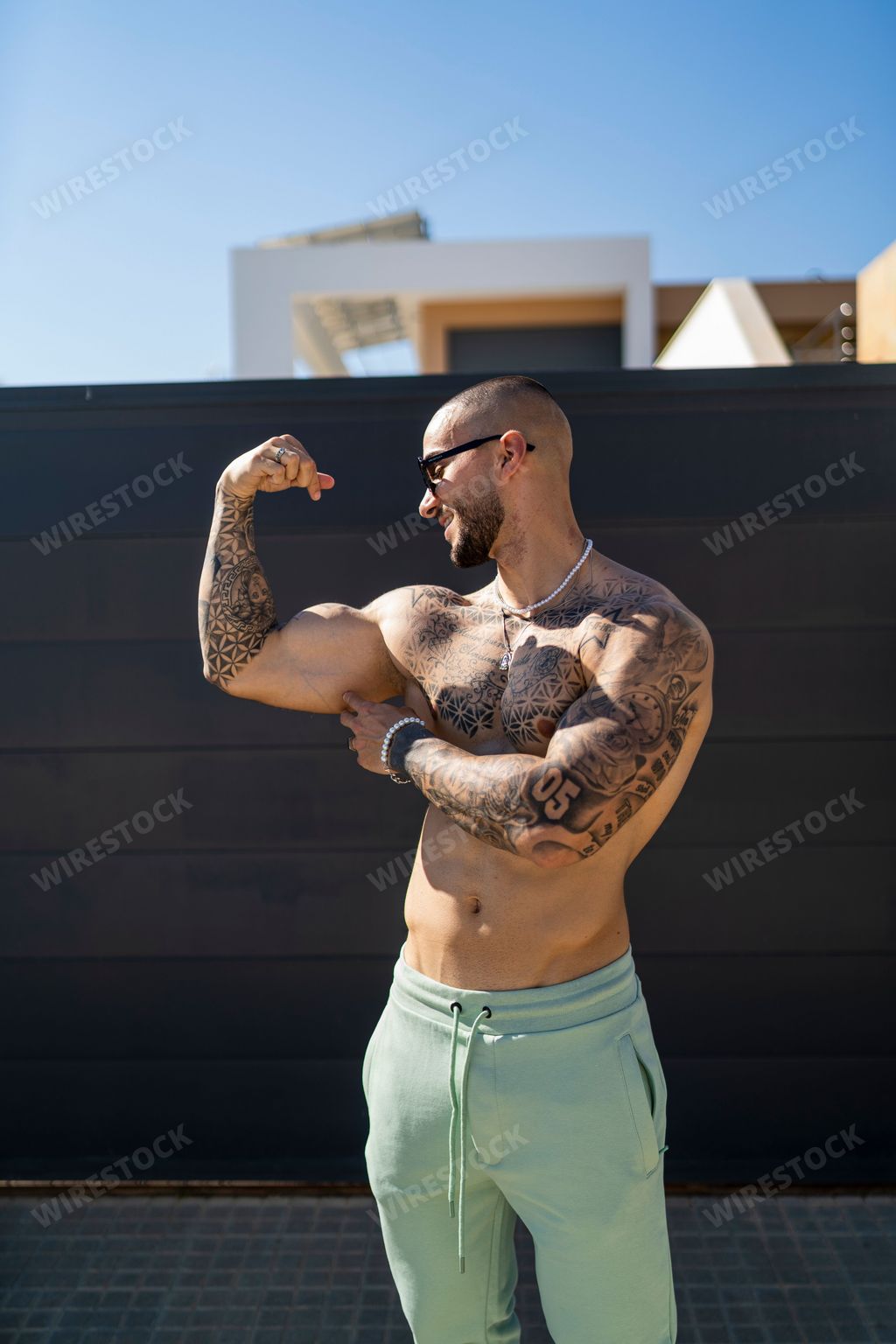 A sexy tattooed man demonstrating inflated biceps