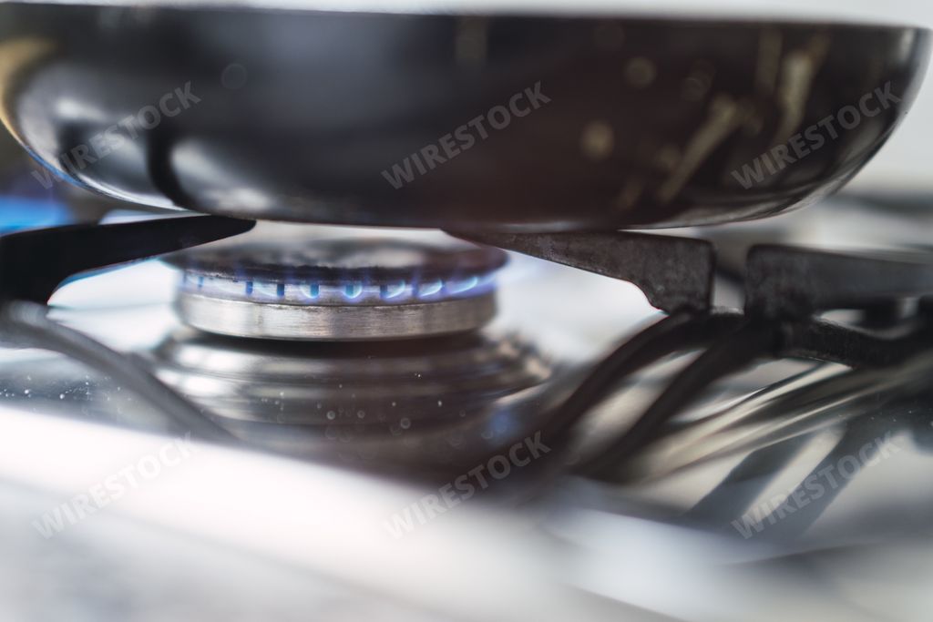 A closeup of a pan on the oven in the kitchen under the lights with a blurry background