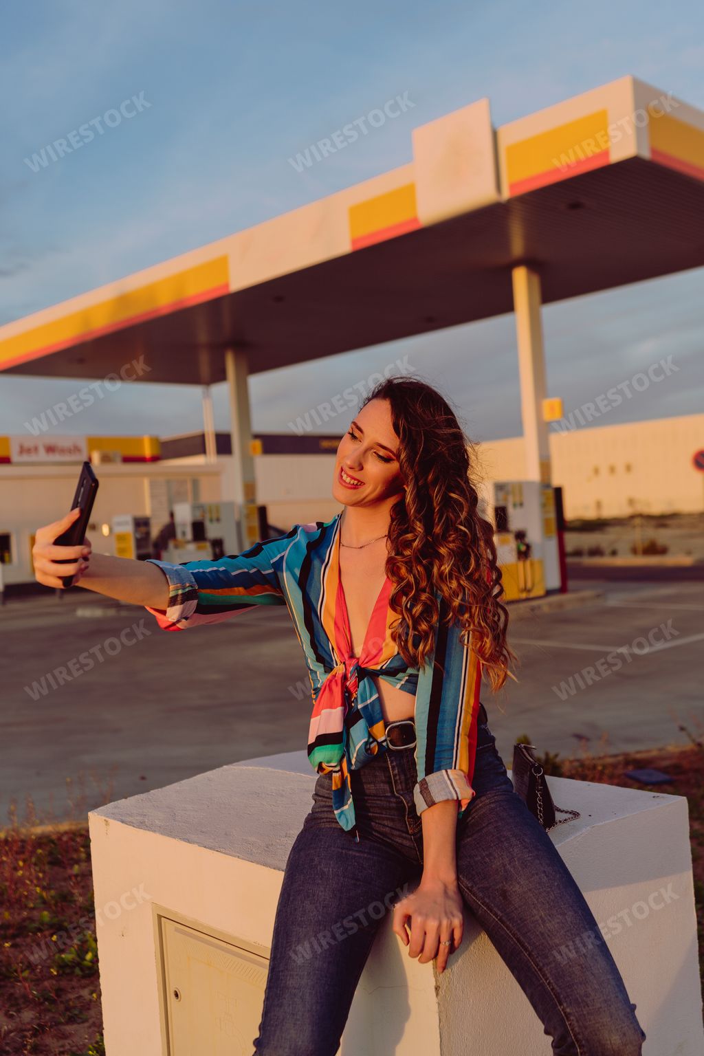 A closeup of an attractive woman taking a selfie at a gas station