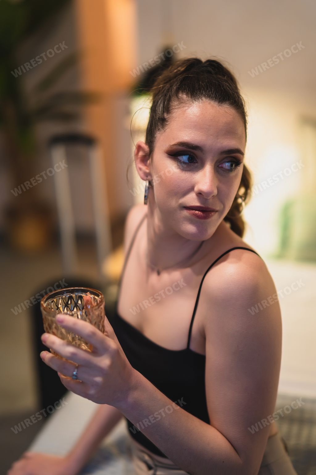 a vertical shot of happy girl drinking juice on bed