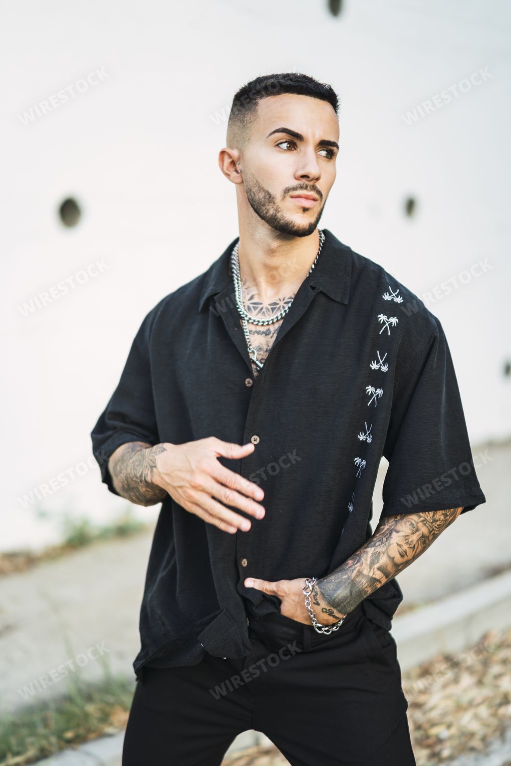 A vertical shot of a young European male with tattoos