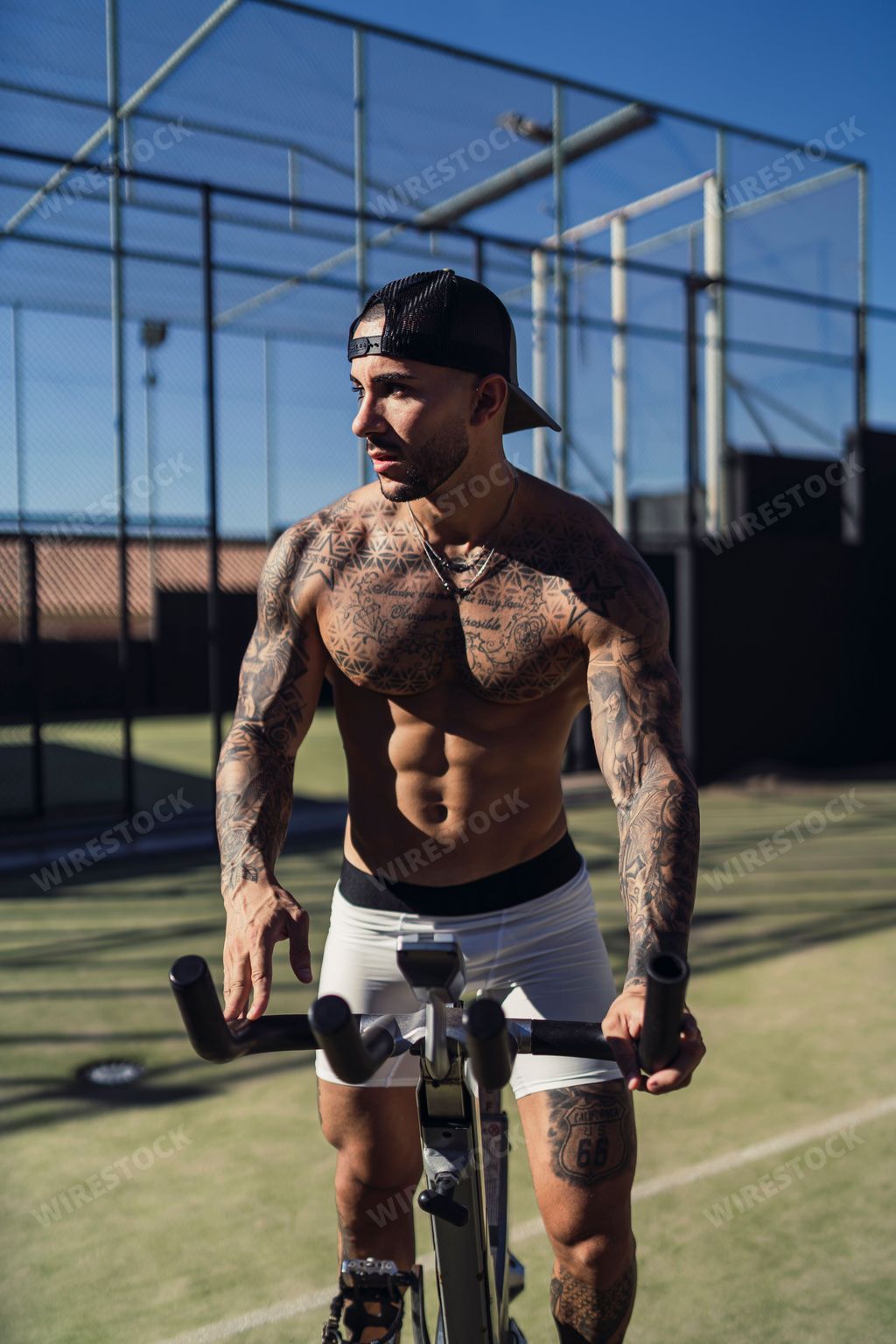 A Caucasian handsome man with tattoos riding bicycle