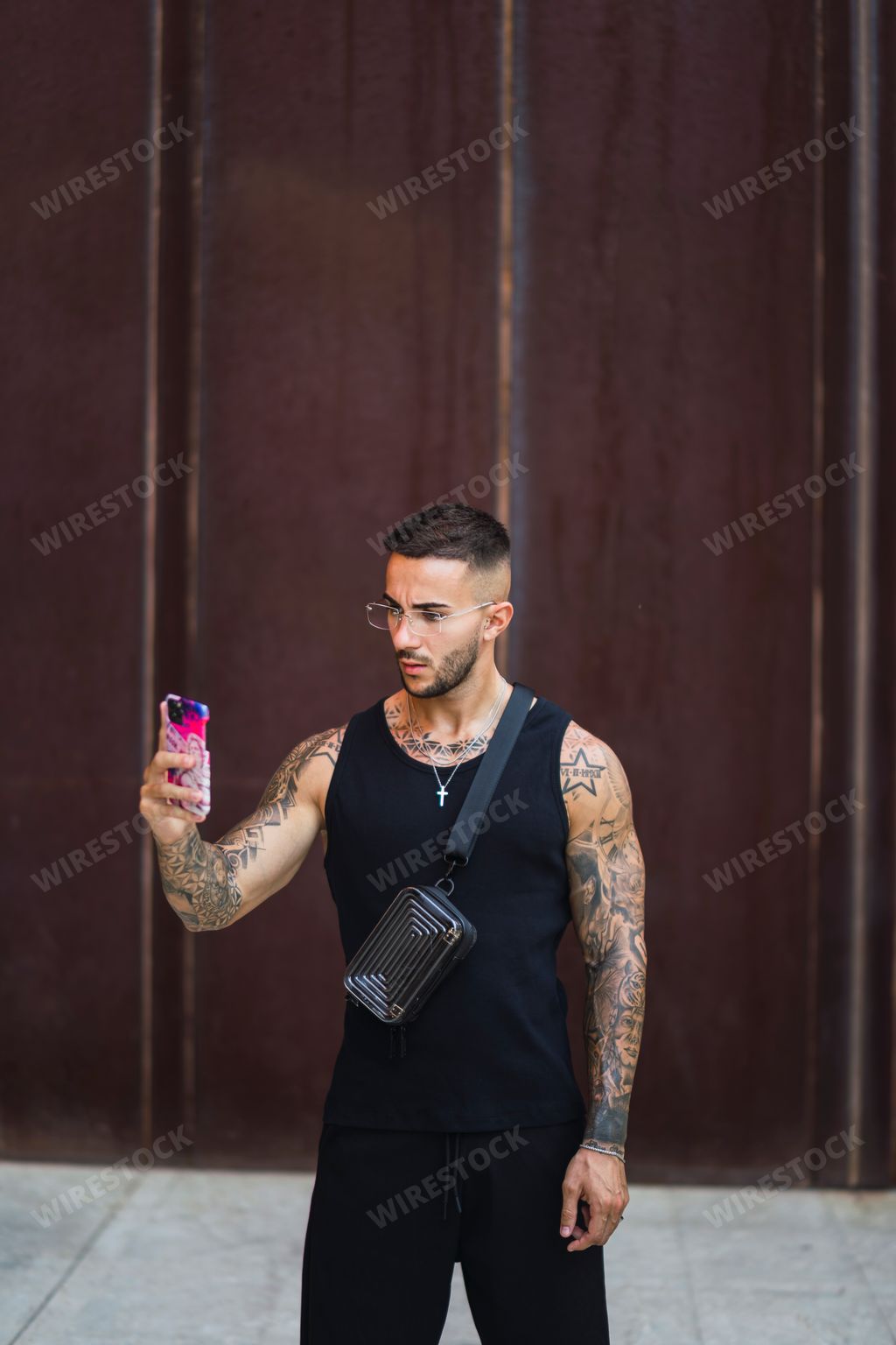 A young man taking a selfiein the street wearing a black suit